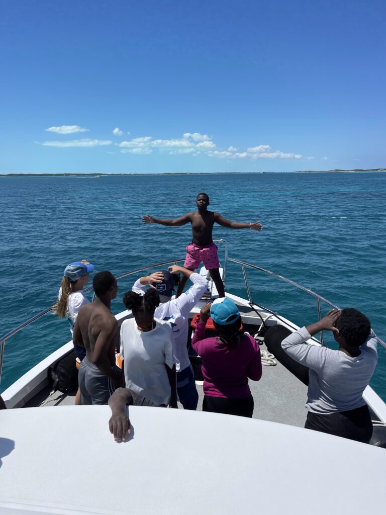 Students participating in teamwork exercises aboard a boat during a youth education program focused on marine conservation.